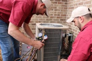 Kurt Zentner & Sons Plumbing & Heating technicians repairing an outdoor AC unit