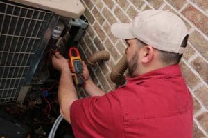 Kurt Zentner & Sons Plumbing & Heating technician repairing an outdoor air conditioner