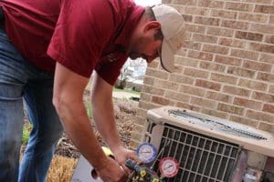 Kurt Zentner & Sons Plumbing & Heating technician repairing an outdoor AC unit