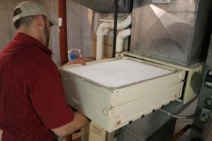 Kurt Zentner & Sons Plumbing & Heating technician replacing a filter