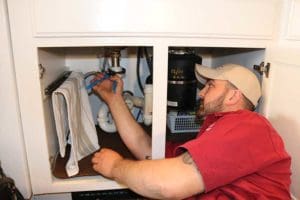 Kurt Zentner & Sons Plumbing & Heating technician repairing a kitchen sink